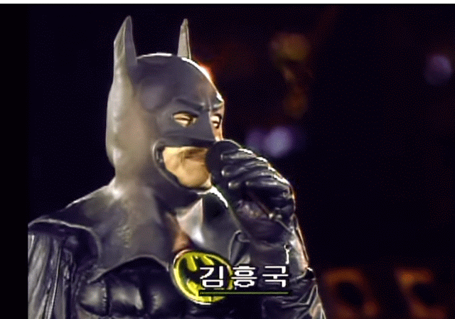 배트맨 의상을 입은 김흥국이 노래하다 아이스크림 두개를 드는짤.gif